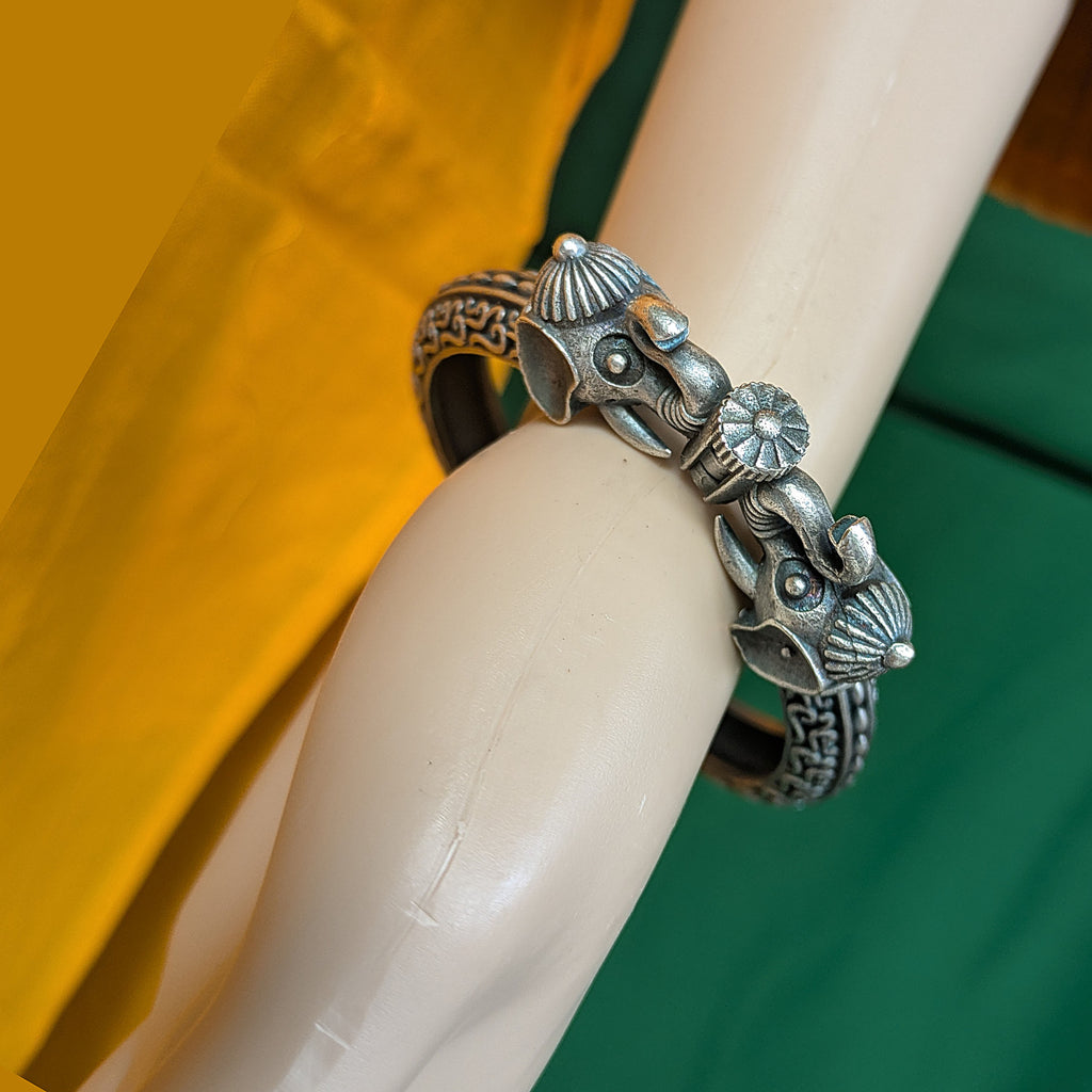Silver bracelet with fox design on a wrist against a blurred background