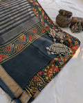 Decorative black saree with colorful patterns and jewelry on a white background