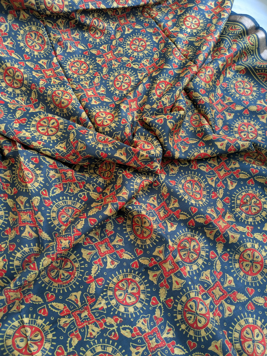 Patterned fabric with red, yellow, and blue design on a blue background