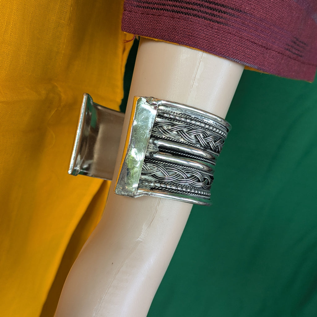 Silver bracelet on a mannequin arm with a blurred background
