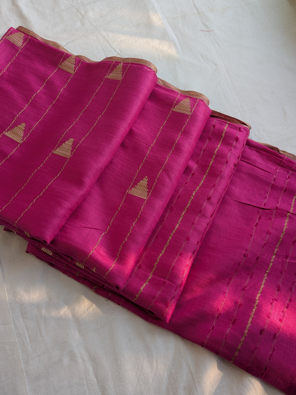 Pink saree with gold patterns on a white background