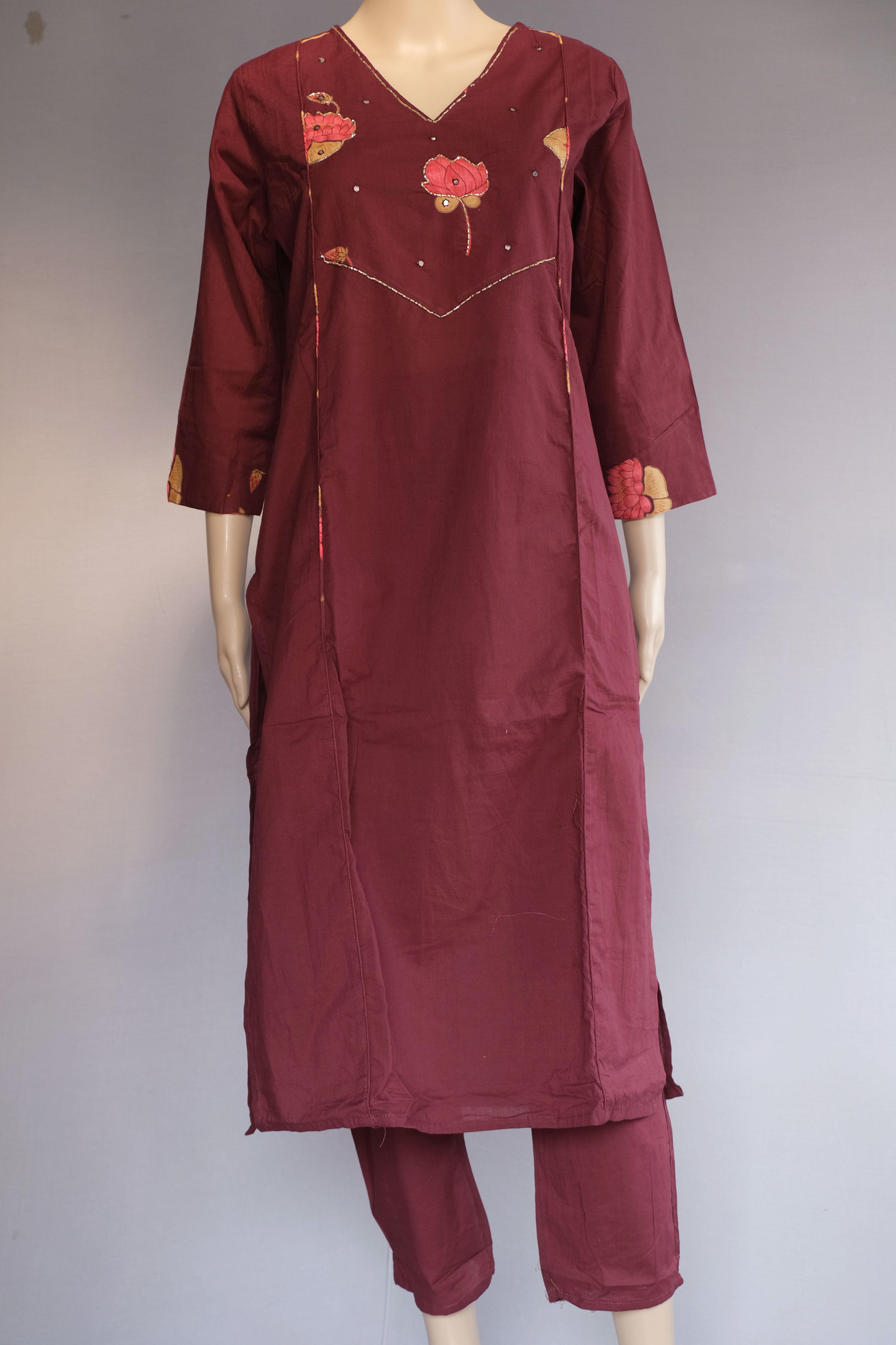 Maroon traditional outfit with floral embroidery on a plain background