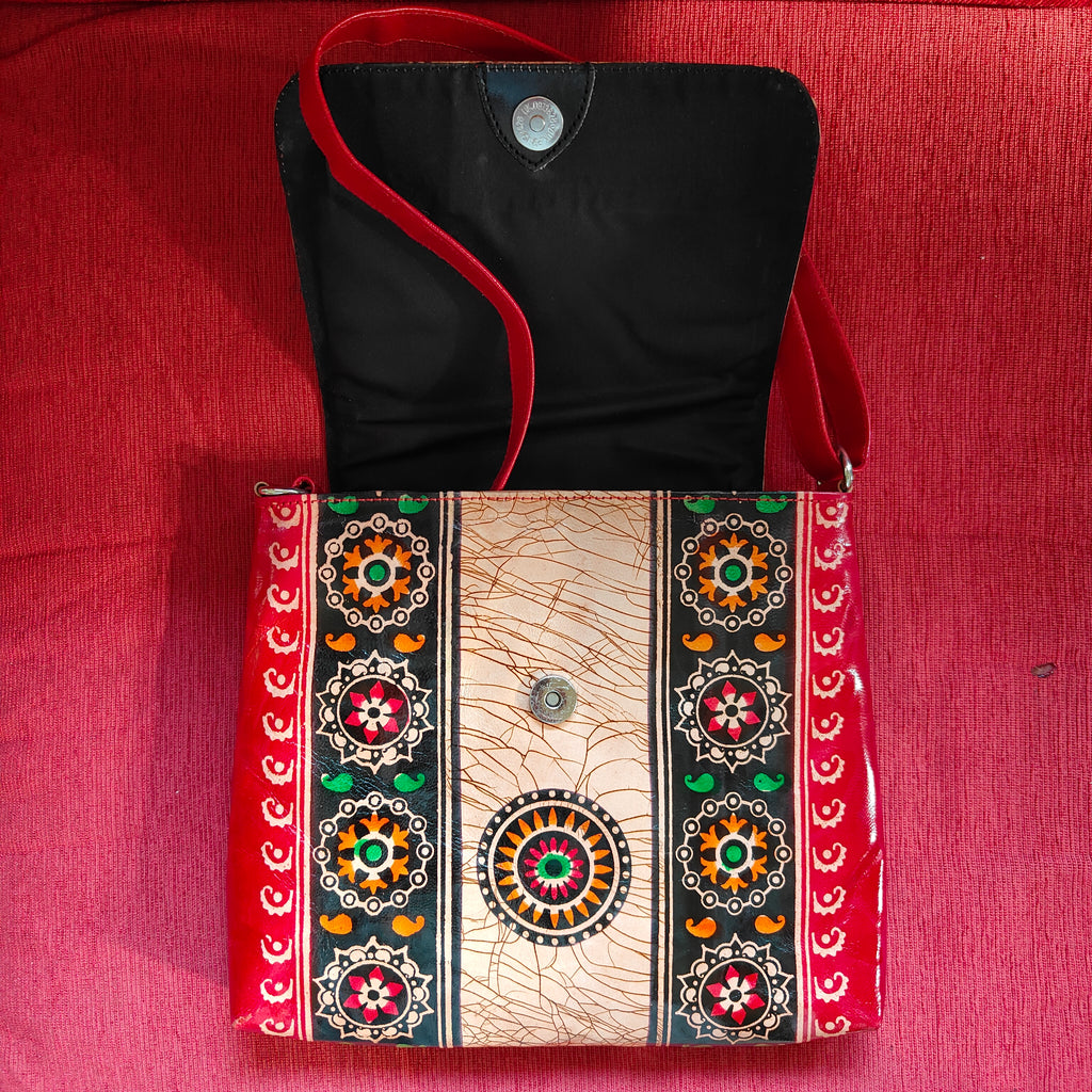 Black bag with red strap and decorative pattern on a red background
