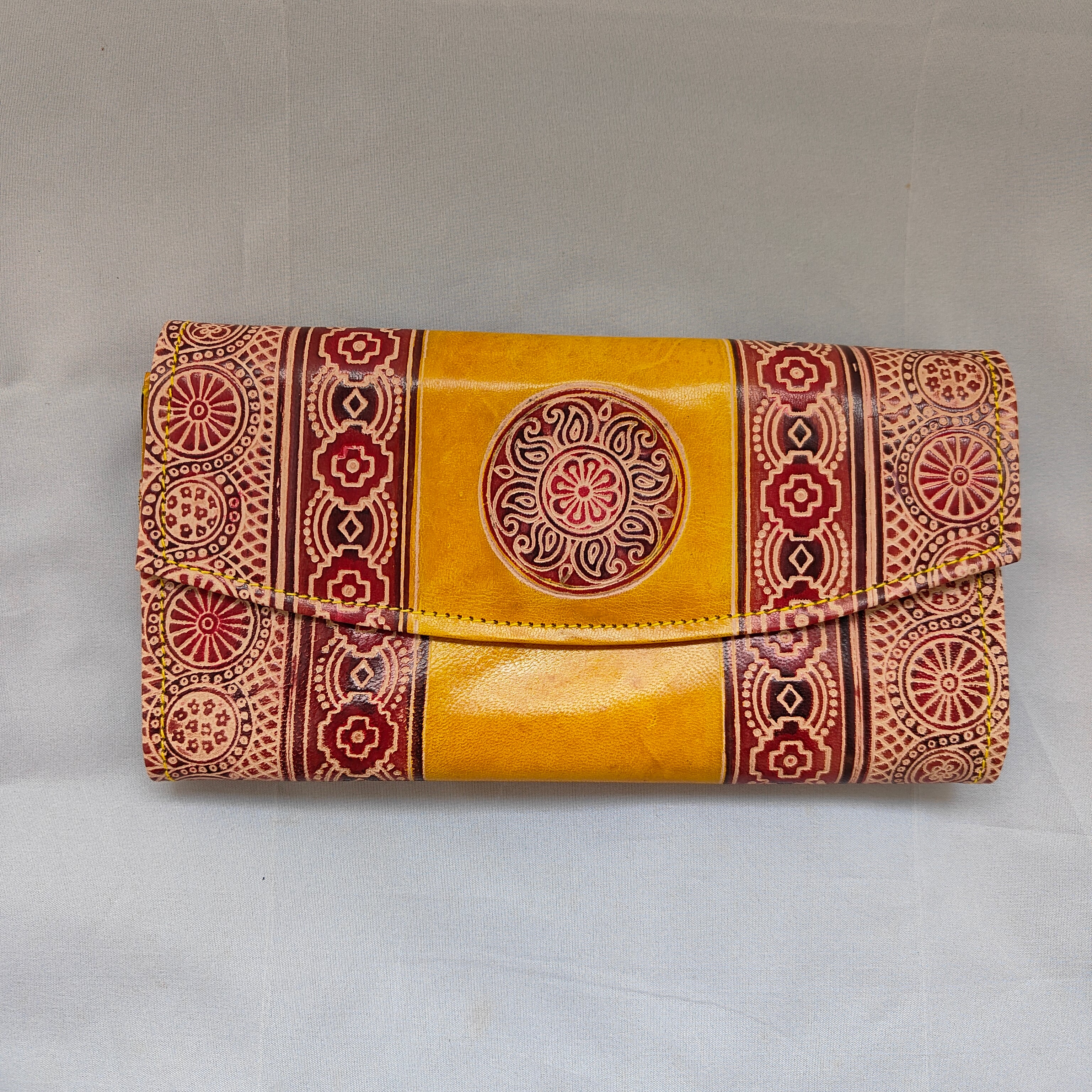 Yellow wallet with red and brown patterns on a white background