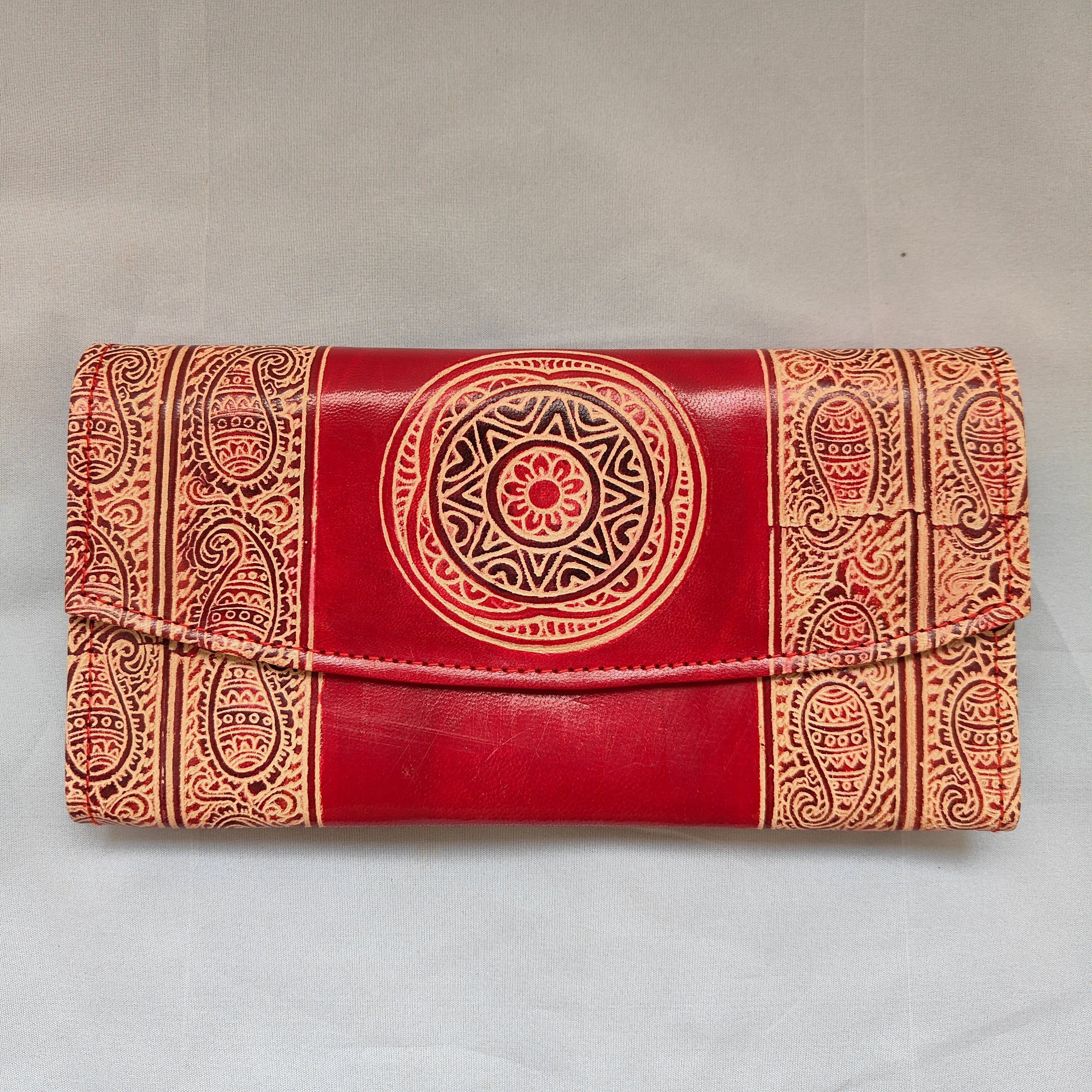 Red notebook with intricate gold patterns on a gray background