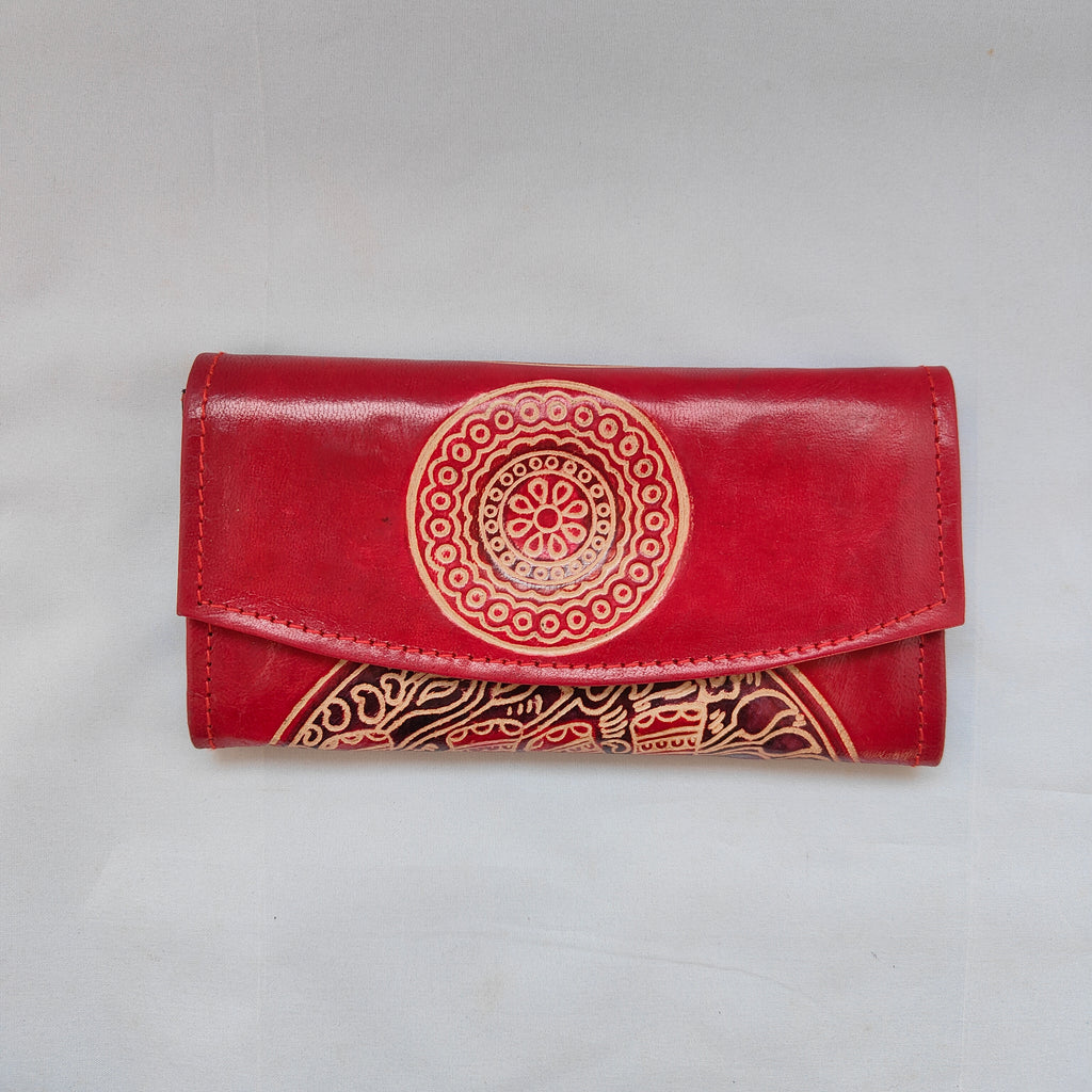 Red wallet with gold embossed design on a light gray background