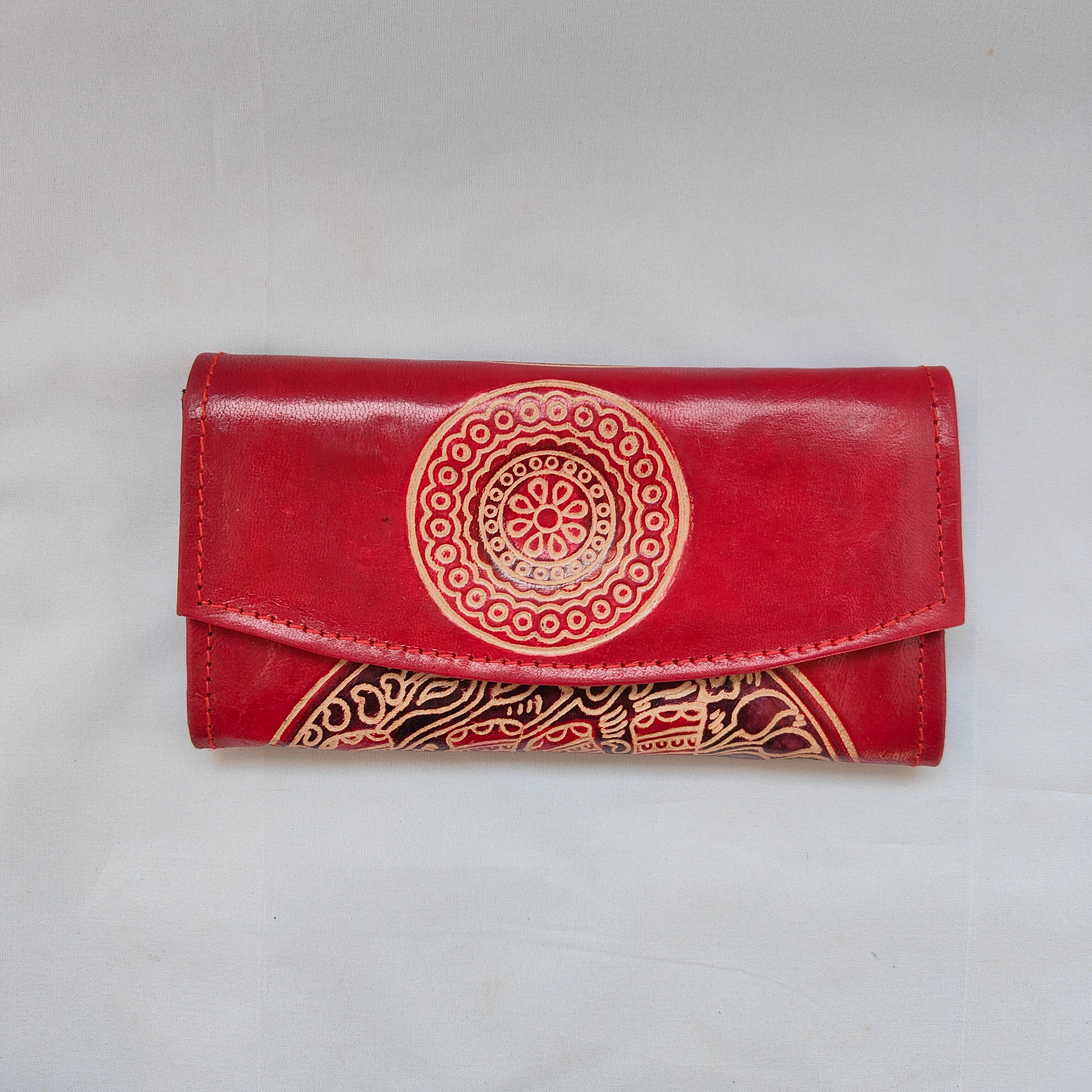 Red wallet with gold embossed design on a light gray background