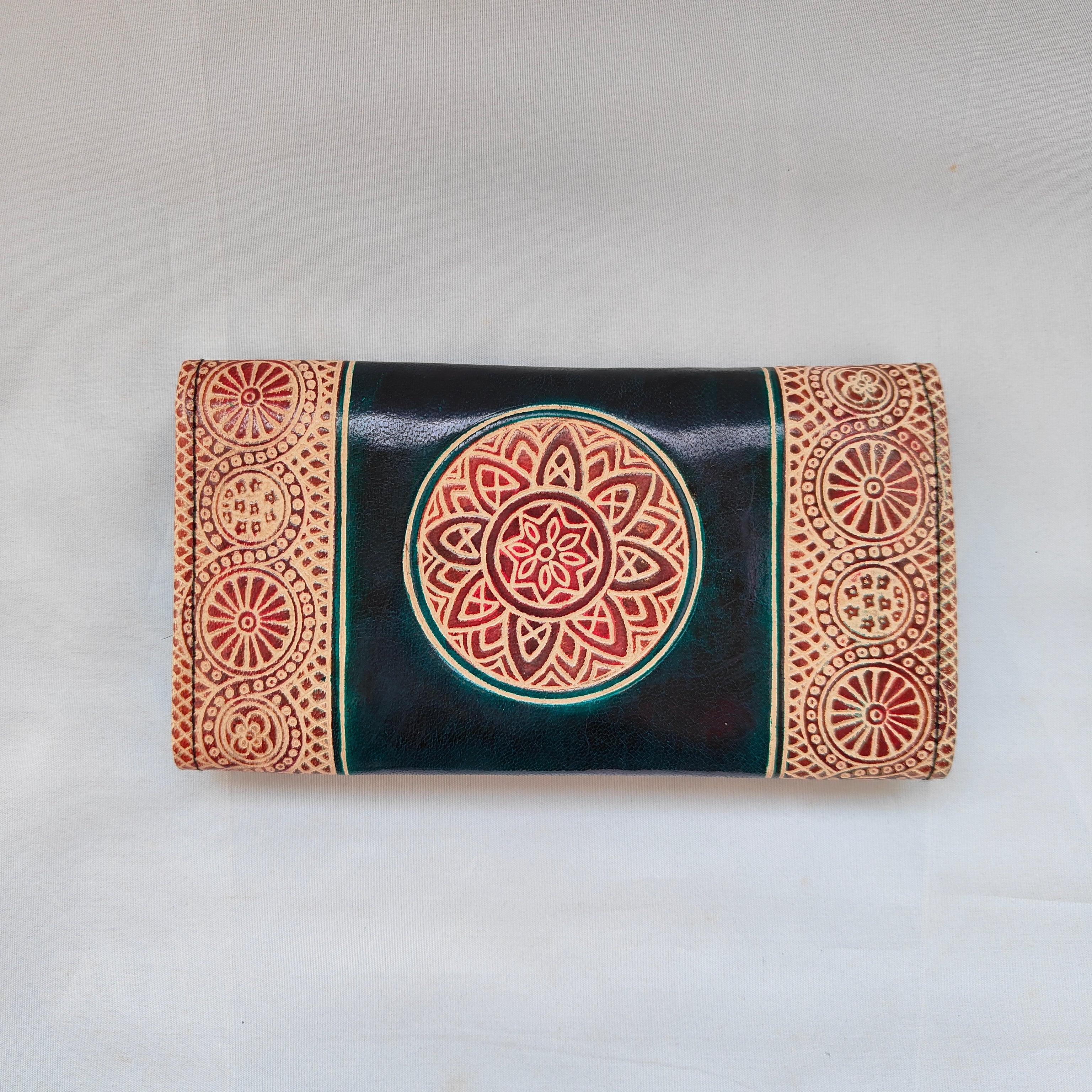 Decorative clutch with mandala design on a plain background