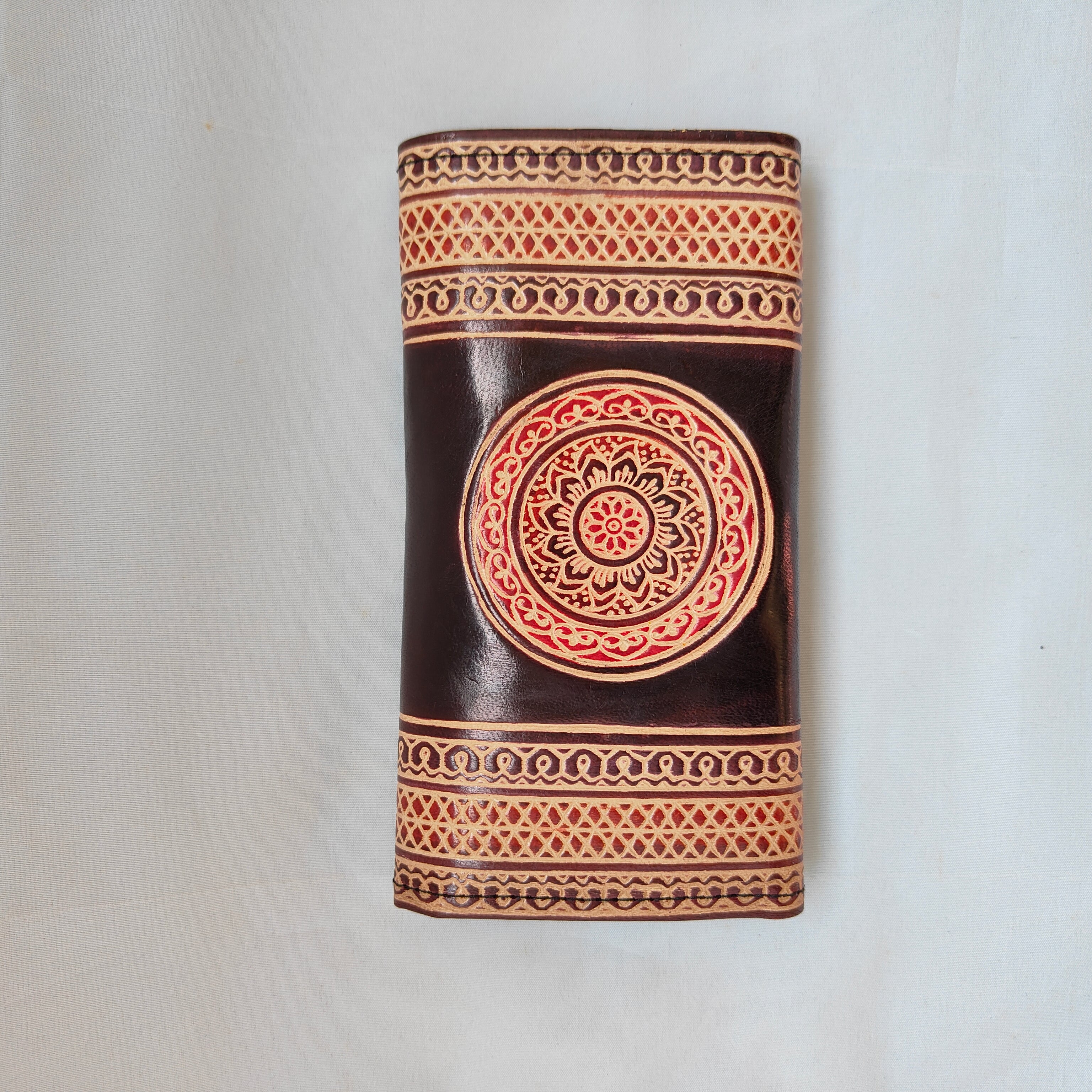 Decorative cylindrical object with intricate patterns on a white background