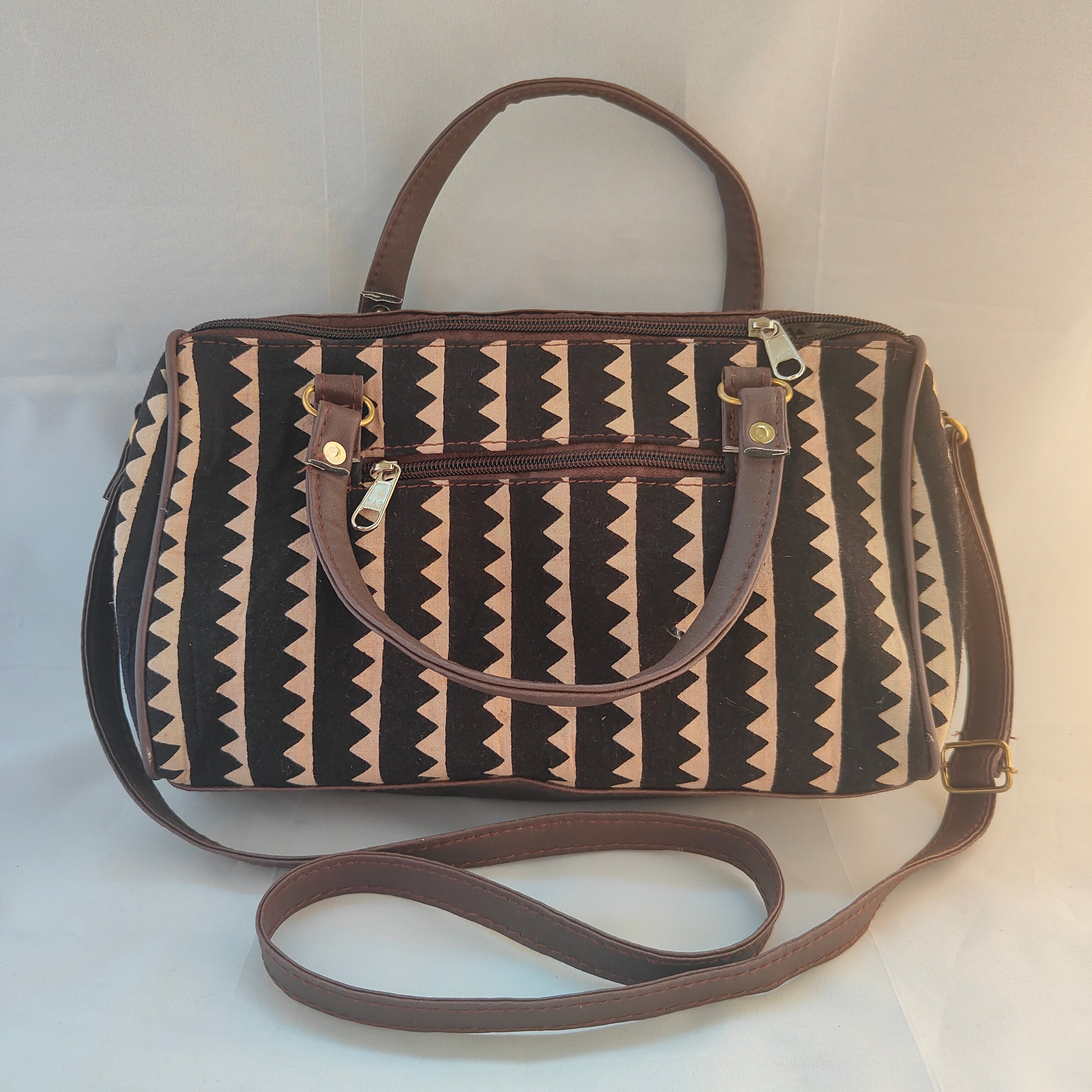 Patterned handbag with a strap on a white background