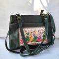 Green handbag with artistic design on a white background