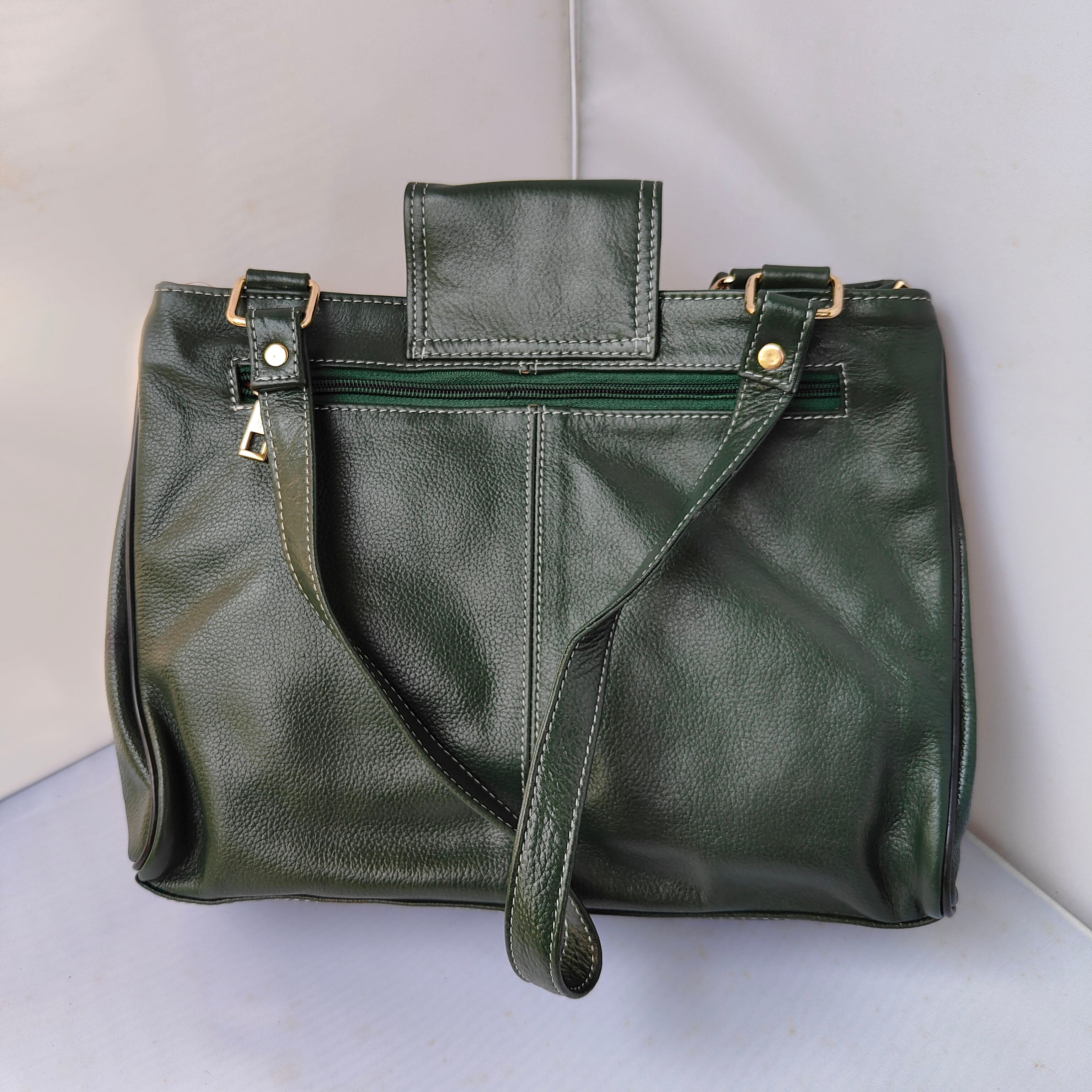 Green leather handbag on a light gray background