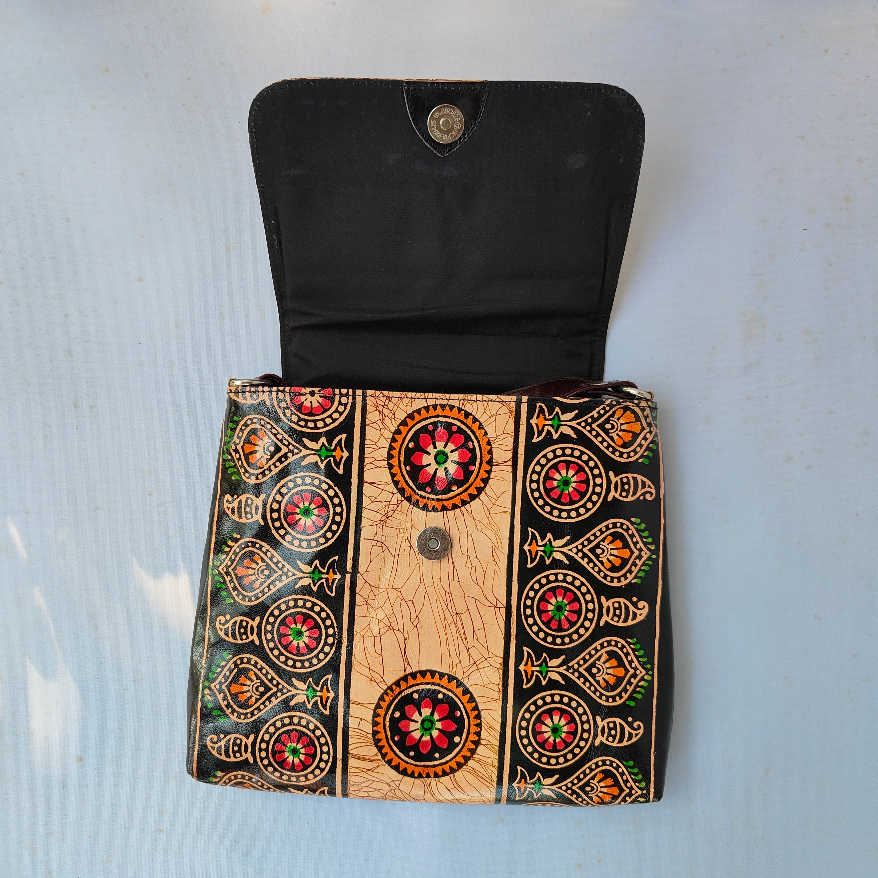 Decorative wallet with intricate patterns on a light blue background