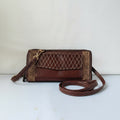 A brown leather crossbody clutch bag with gold geometric patterns on the borders and a quilted diamond design on the front flap, featuring a matching adjustable shoulder strap.