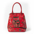 A red leather handbag featuring a hand-painted black and gold owl design with floral accents, set against a plain light background.