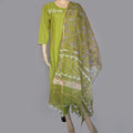 Green embroidered traditional outfit on a mannequin against a gray background