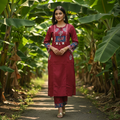 Woman in a red traditional outfit standing in a banana plantation