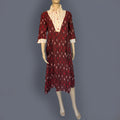 Red patterned dress on a mannequin against a dark gray background