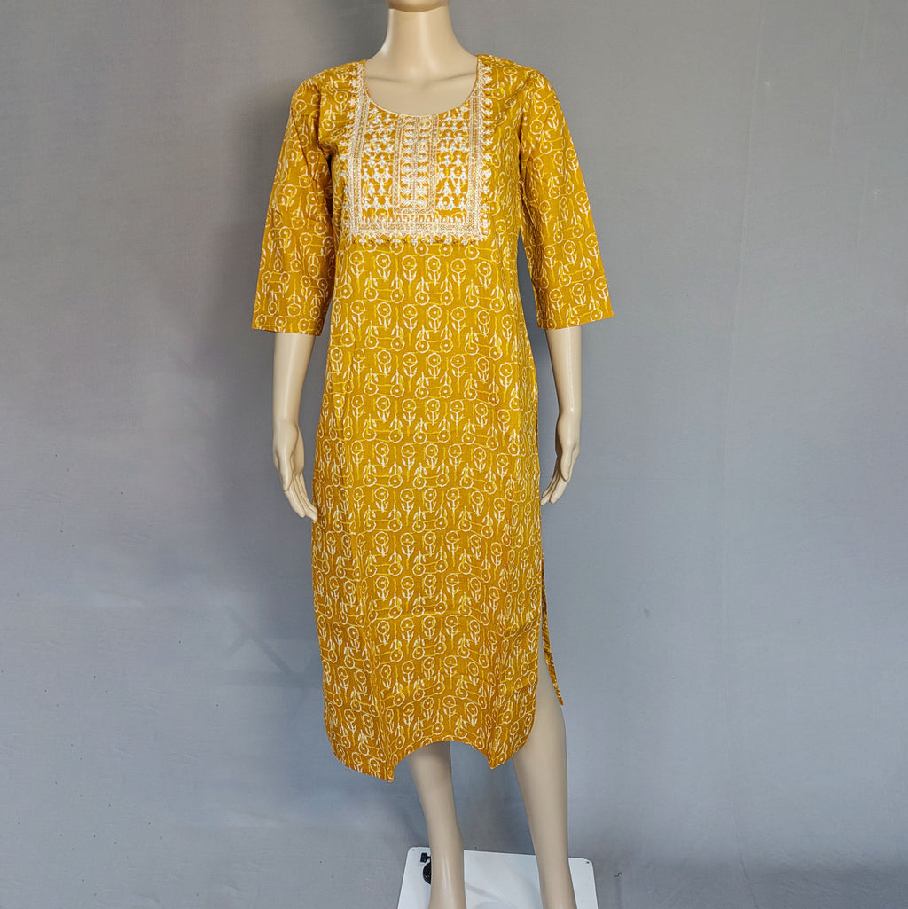 Yellow patterned dress on a mannequin against a gray background