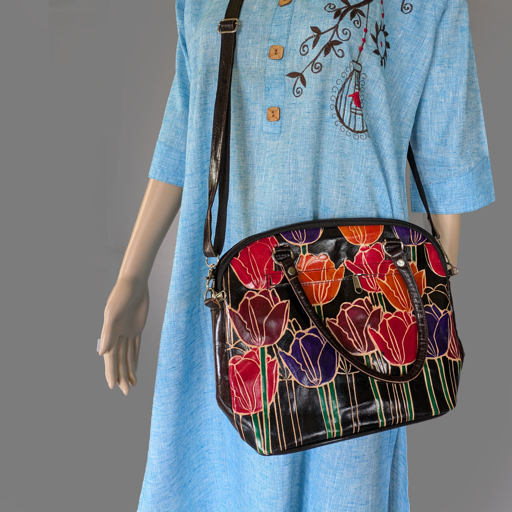 Mannequin wearing a blue dress with a floral-patterned handbag.