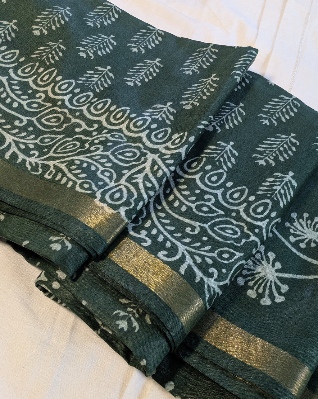 Green fabric with white floral patterns on a white background