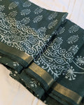 Green fabric with white floral patterns on a white background