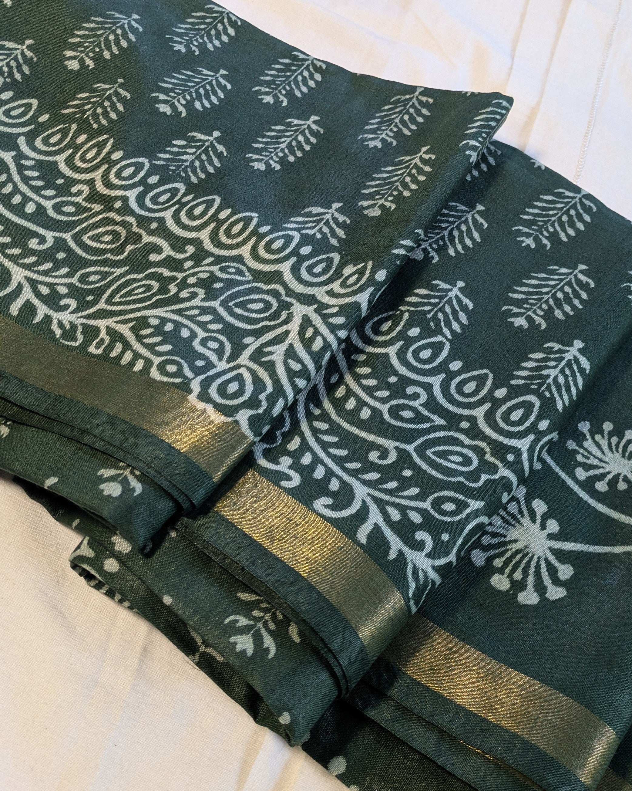 Green fabric with white floral patterns on a white background